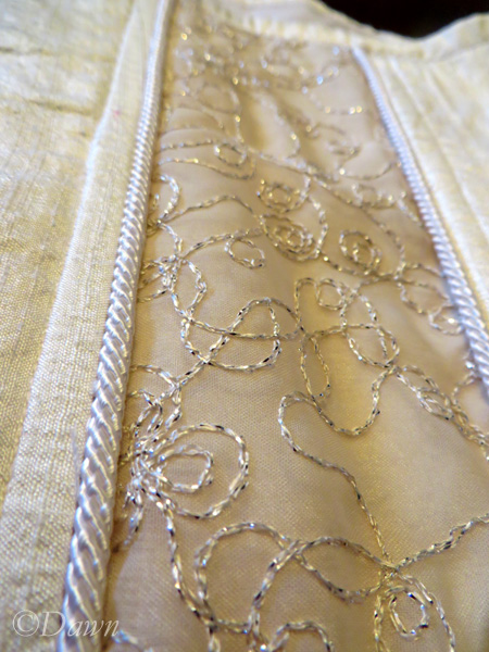 Close up of the white silk, corded piping, and the sheer embroidered fabric